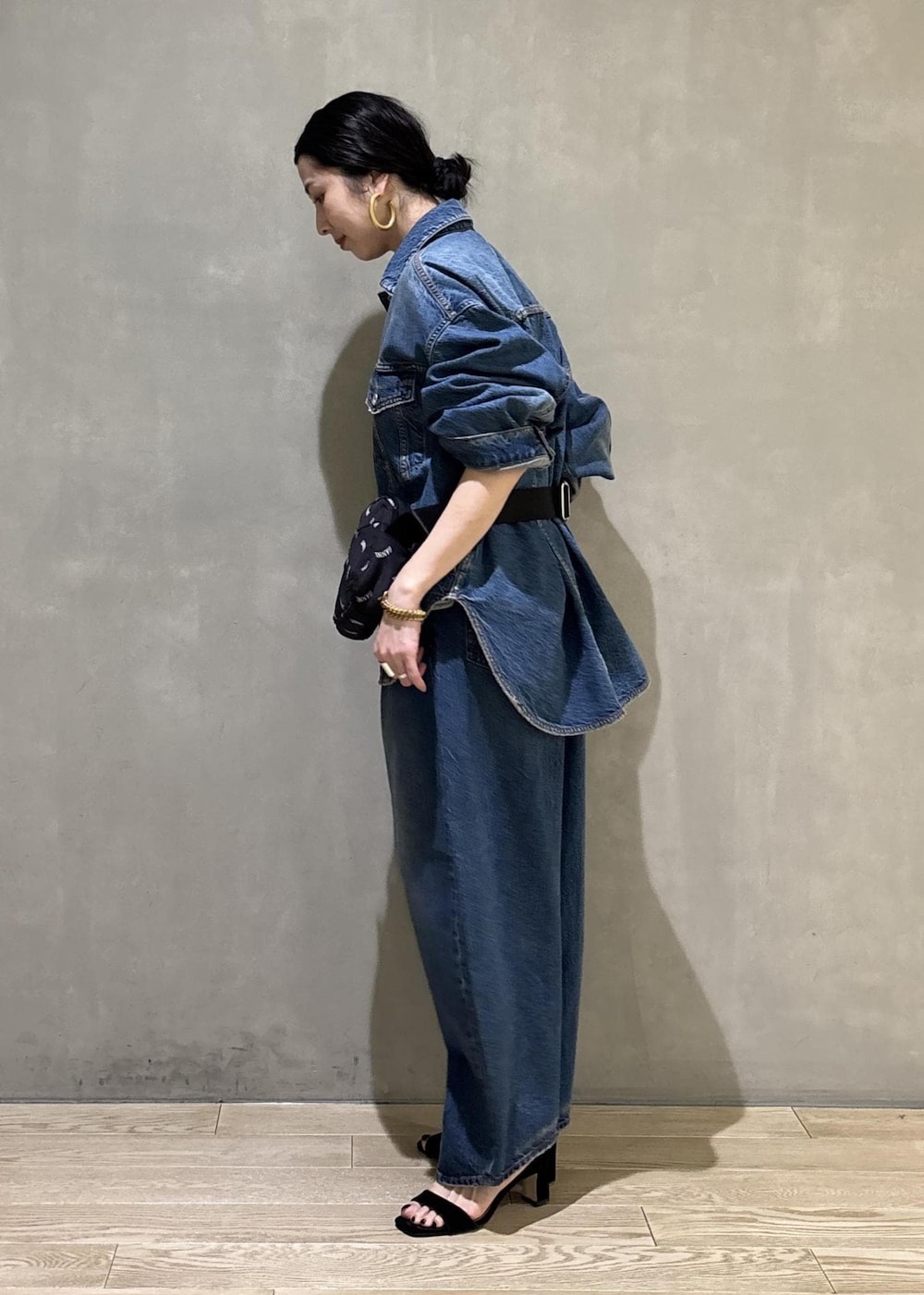 ブルー系のデニムジャケット、ブルー系のデニムパンツ、ブラック系のトートバッグを着用したレディースの春コーディネートの7枚目の写真