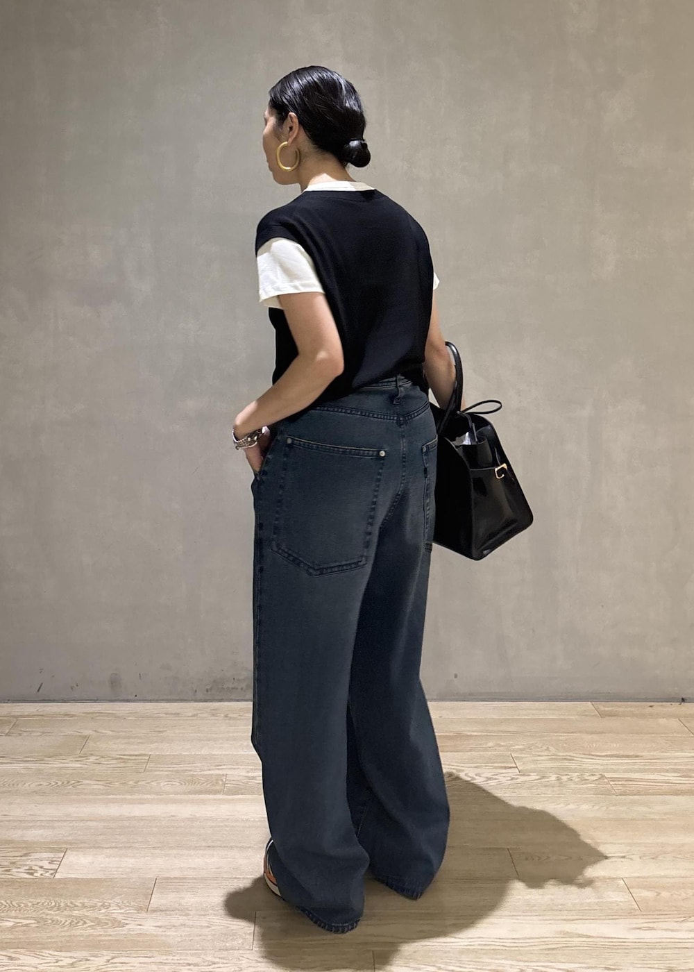 ブラック系のトートバッグ、ブラック系のTシャツ/カットソー、ブルー系のデニムパンツを着用したレディースの夏コーディネートの6枚目の写真