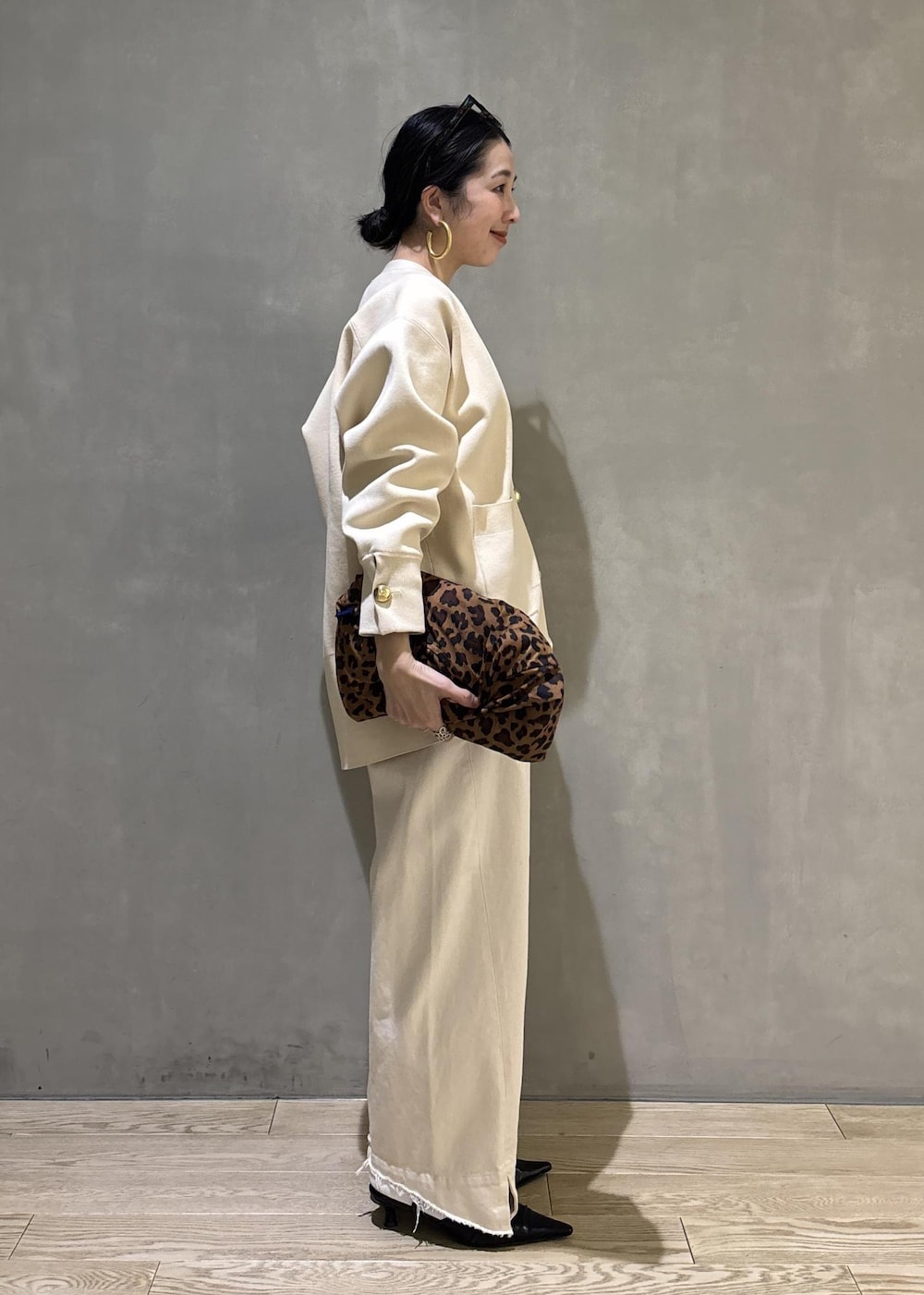 ブラック系のサンダル、ホワイト系のデニムパンツ、ホワイト系のカーディガン/ボレロを着用したレディースの冬コーディネートの4枚目の写真