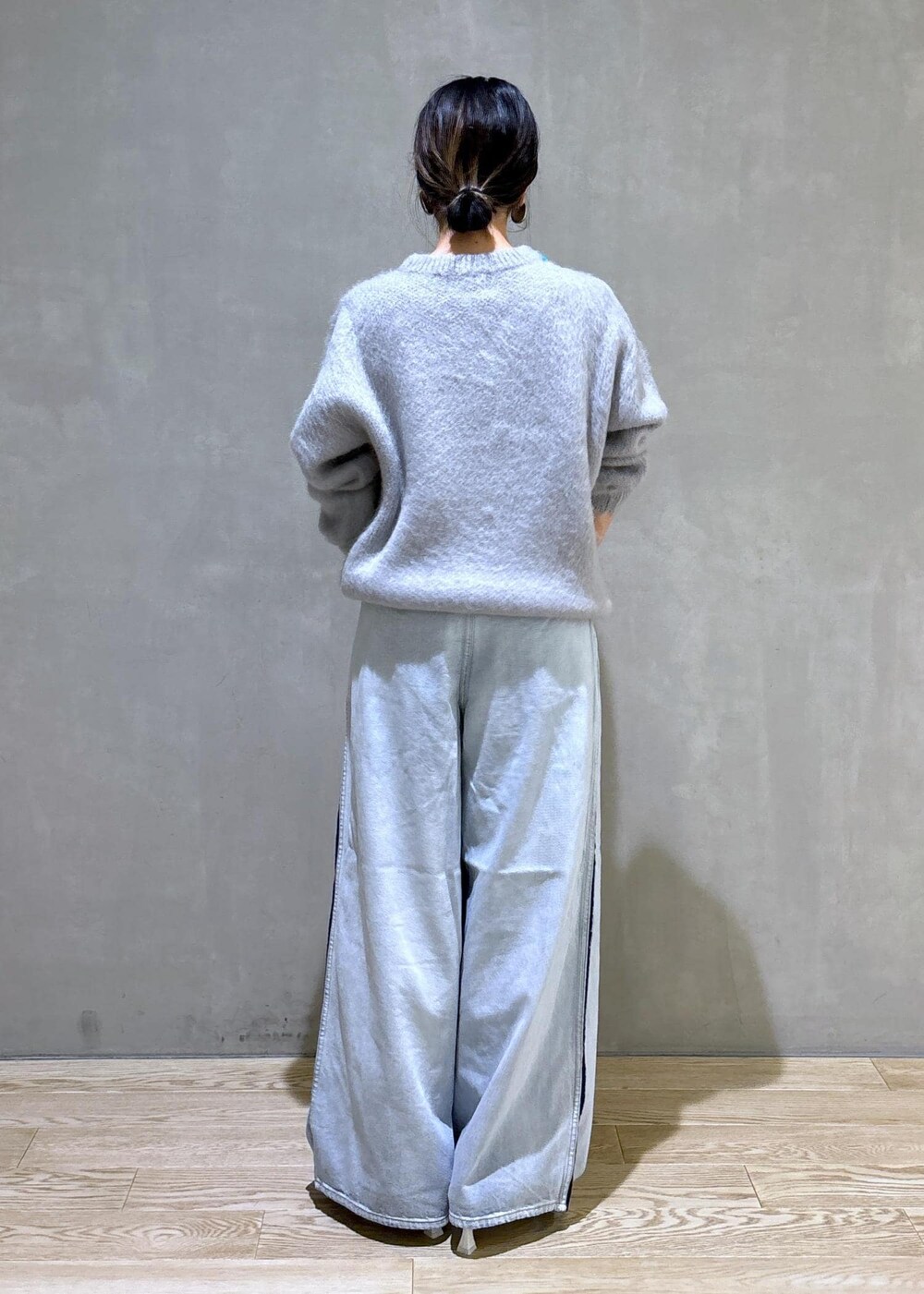 ホワイト系のパンプス、シルバー系のトートバッグ、ブルー系のその他パンツを着用したレディースの秋コーディネートの5枚目の写真