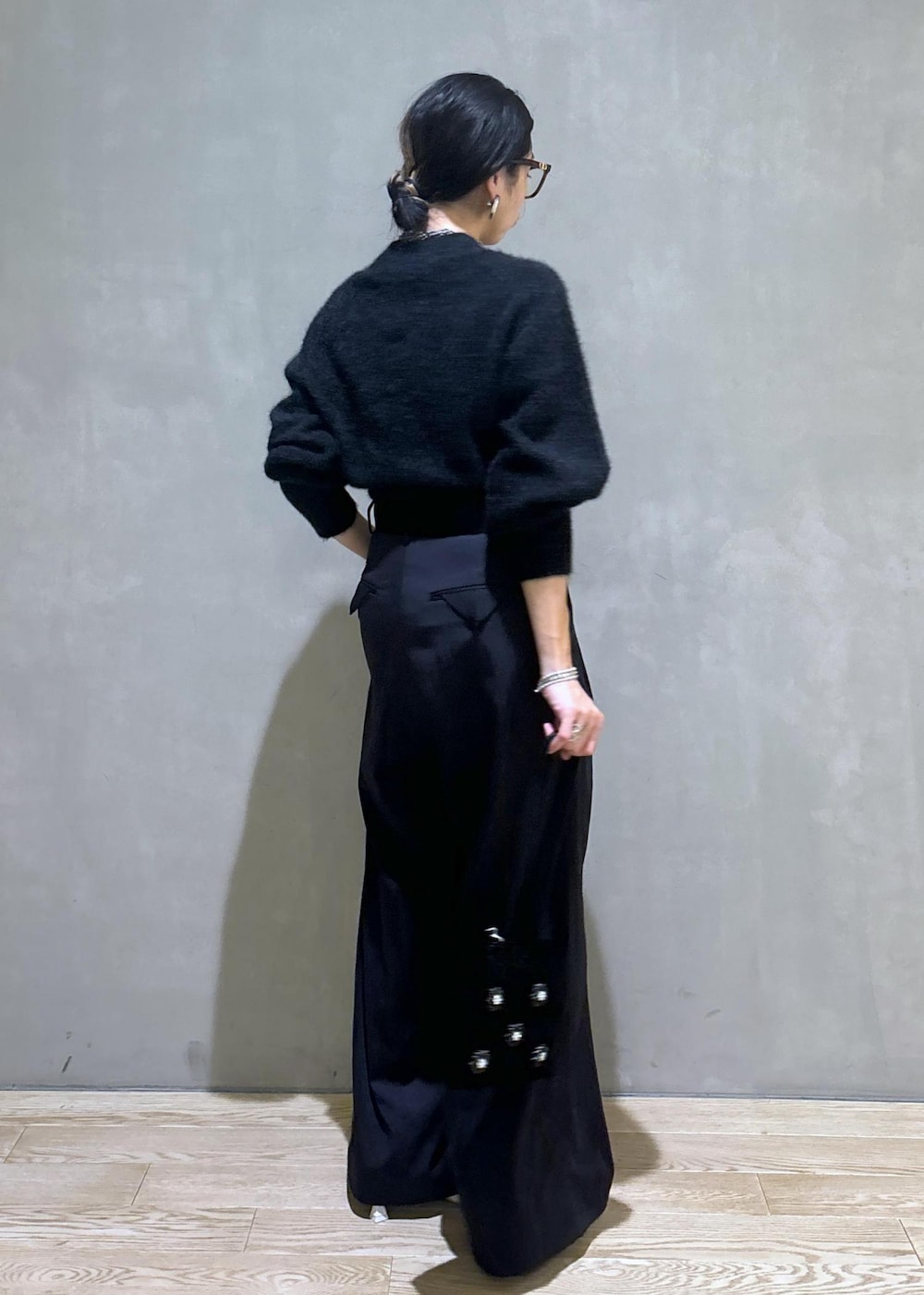 ホワイト系のパンプス、ブラック系のスラックス、グレー系のニット/セーターを着用したレディースの秋コーディネートの3枚目の写真