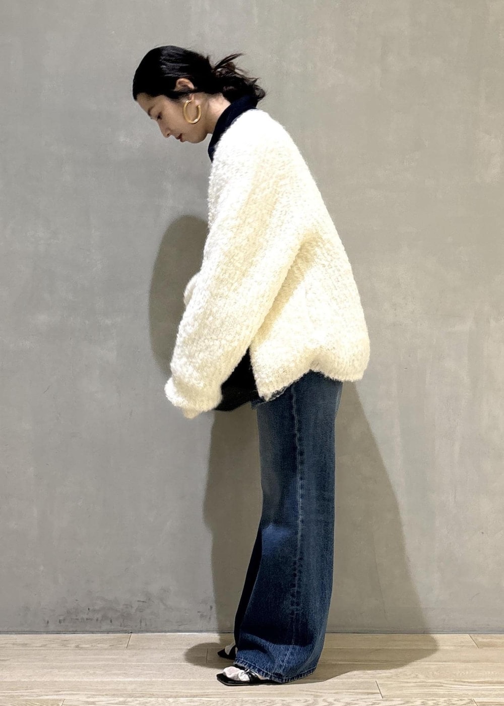 ブラック系のショルダーバッグ、ブルー系のデニムパンツ、ブルー系のカバーオールを着用したレディースの秋コーディネートの4枚目の写真