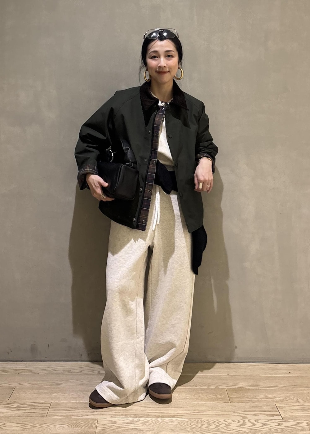 ブラック系のハンドバッグ、グリーン系のその他アウター、ホワイト系のその他パンツを着用したレディースの冬コーディネートの6枚目の写真