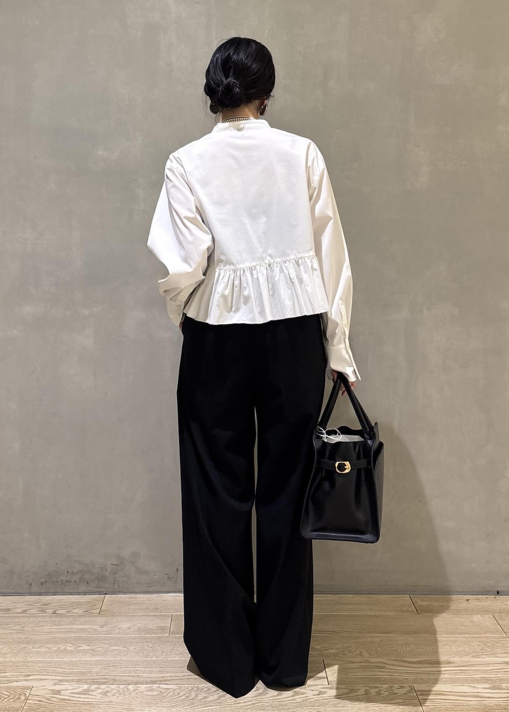 ホワイト系のシャツ/ブラウス、ブラック系のスラックス、ブラック系のトートバッグを着用したレディースの冬コーディネートの6枚目の写真