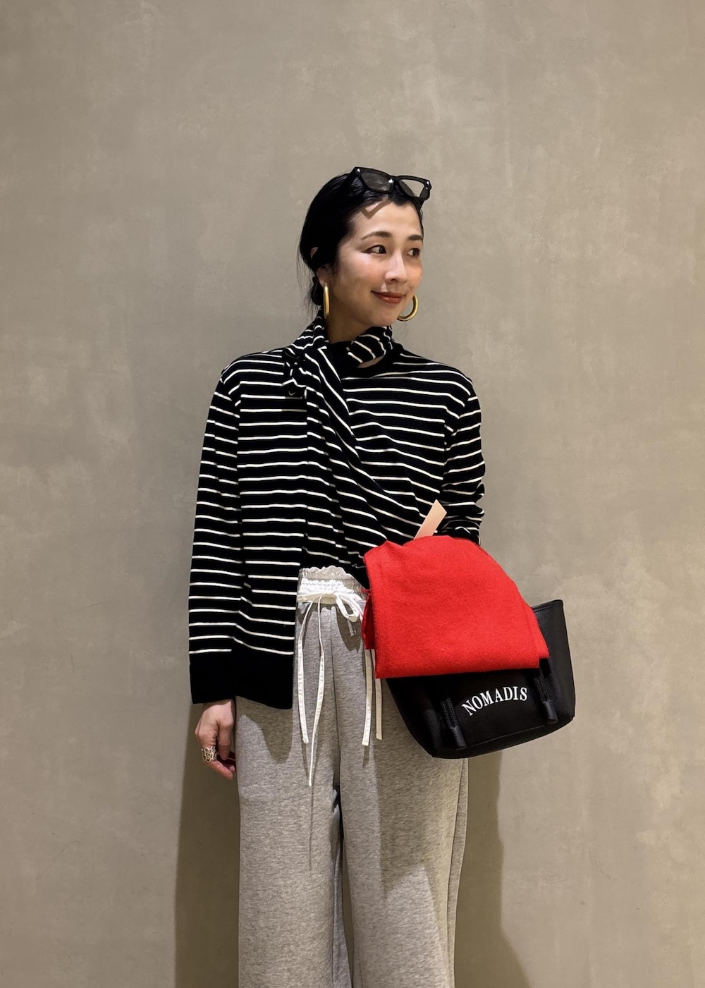 グレー系のその他パンツ、レッド系のマフラーを着用したレディースの冬コーディネートの7枚目の写真