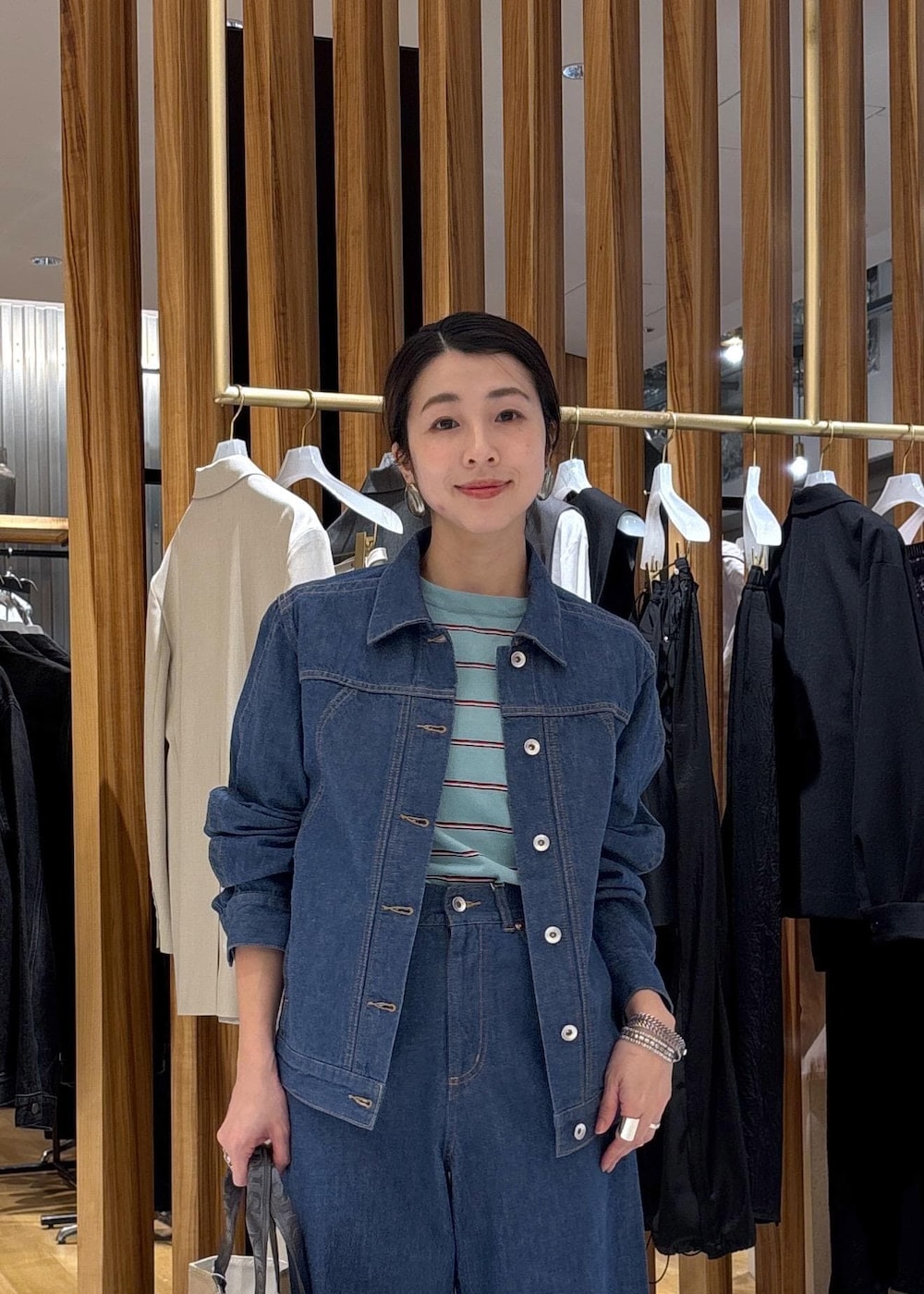 ベージュ系のハンドバッグ、ブルー系のTシャツ/カットソー、ブルー系のブルゾンを着用したレディースの冬コーディネートの9枚目の写真