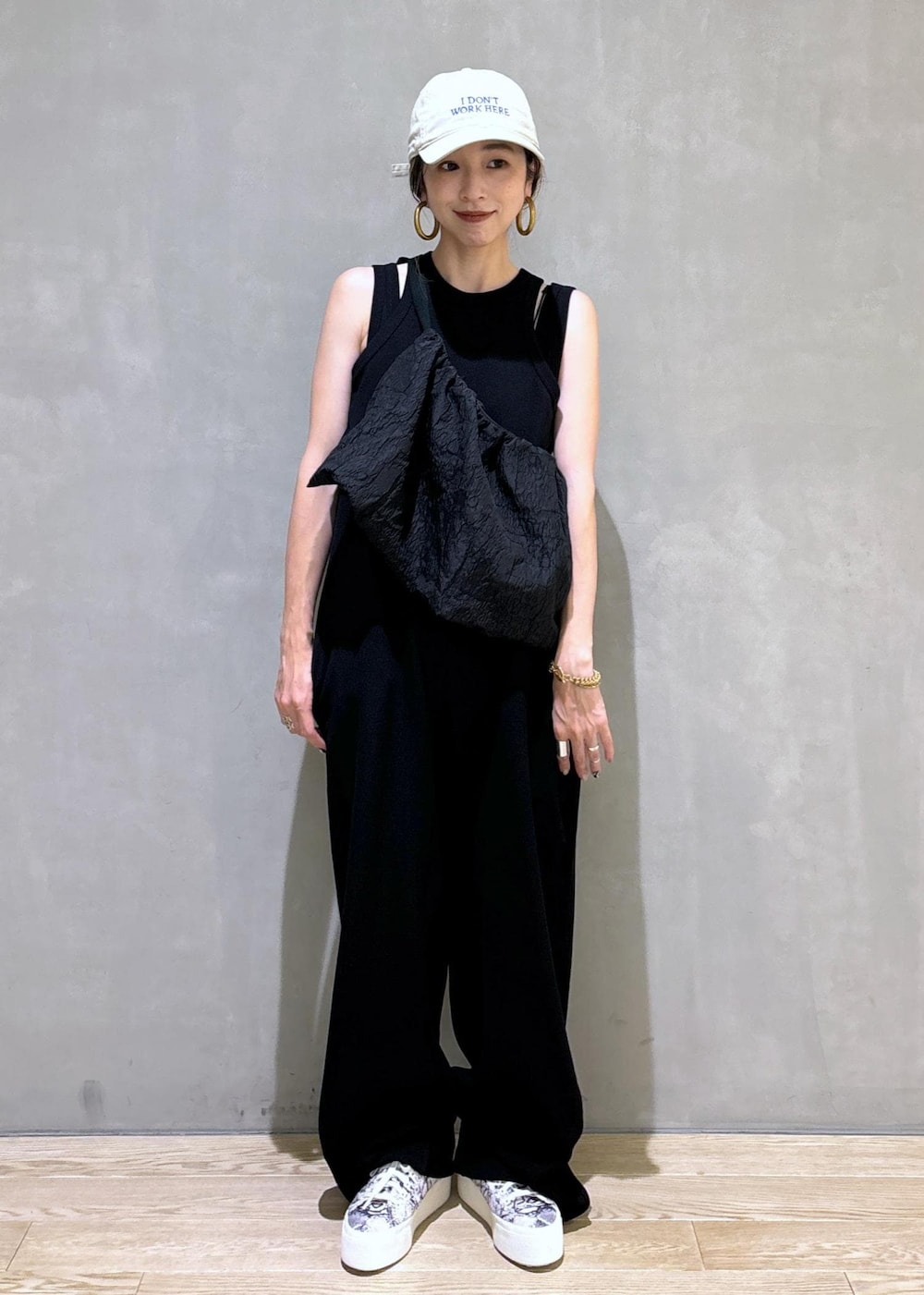 ブラック系のスニーカー、ブラック系のつなぎ/オールインワン、ベージュ系のキャップを着用したレディースの夏コーディネートの6枚目の写真