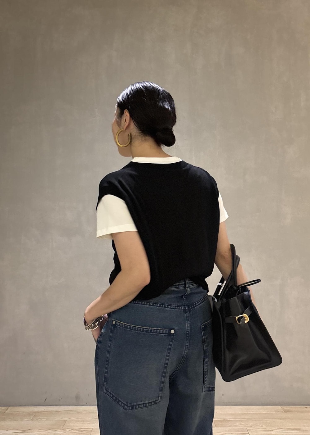ブラック系のトートバッグ、ブラック系のTシャツ/カットソー、ブルー系のデニムパンツを着用したレディースの夏コーディネートの10枚目の写真