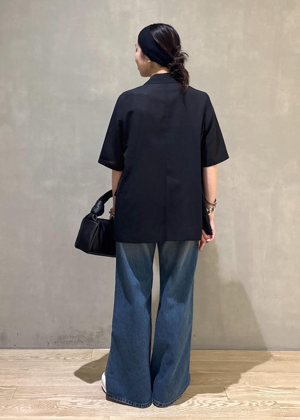 ブラック系のシャツ/ブラウス、ブルー系のデニムパンツ、シルバー系のネックレスを着用したレディースの夏コーディネートの5枚目の写真