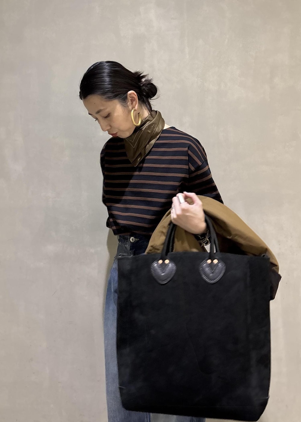 ブルー系のデニムパンツ、イエロー系のブルゾン、ブラウン系のTシャツ/カットソーを着用したレディースの夏コーディネートの7枚目の写真