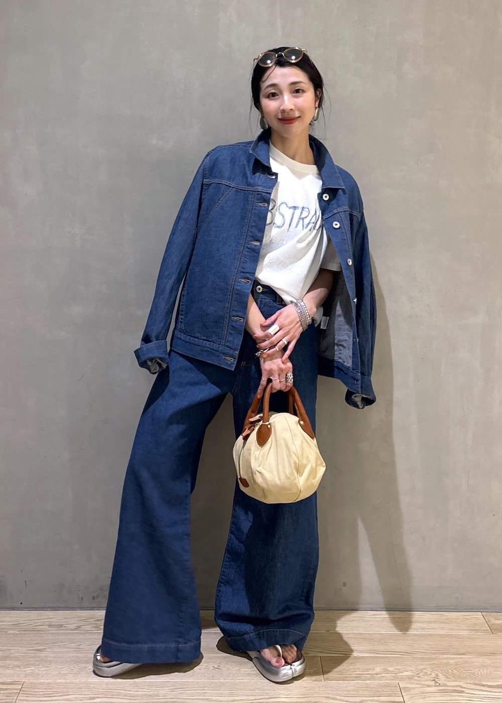 ブルー系のブルゾン、ブルー系のデニムパンツ、ホワイト系のTシャツ/カットソーを着用したレディースの春コーディネートの2枚目の写真