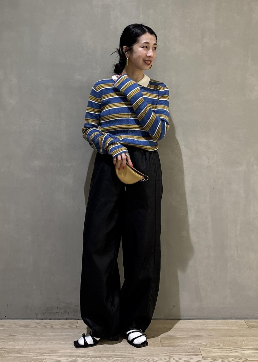 ブルー系のポロシャツ、ブラック系のその他パンツ、イエロー系のキーホルダーを着用したレディースの秋コーディネートの2枚目の写真