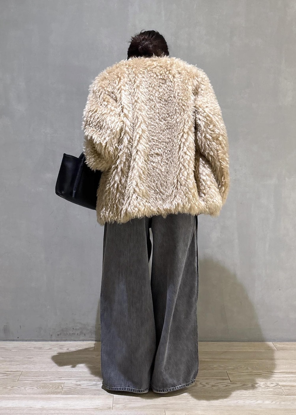 ブラック系のデニムパンツ、ブラック系のTシャツ/カットソー、ベージュ系のその他アウターを着用したレディースの秋コーディネートの4枚目の写真