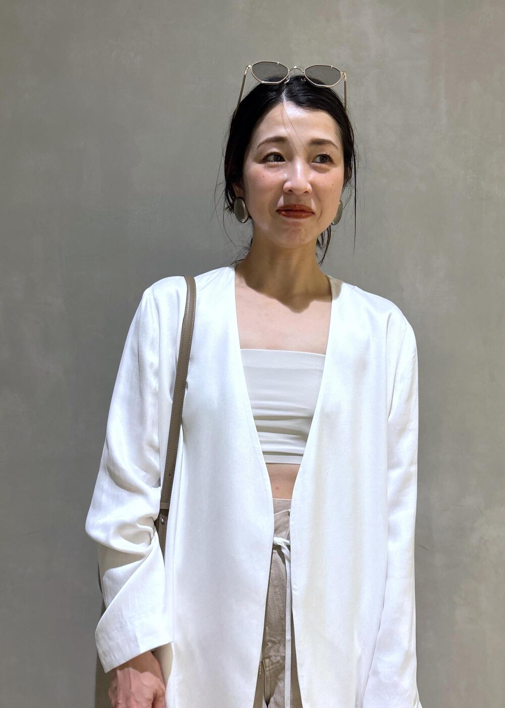 ホワイト系のノーカラージャケット、ホワイト系のデニムパンツ、グレー系のショルダーバッグを着用したレディースの春コーディネートの9枚目の写真