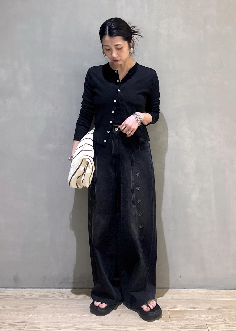 ブラック系のカーディガン/ボレロ、ホワイト系のショルダーバッグ、ブラック系のデニムパンツを着用したレディースの春コーディネートの5枚目の写真