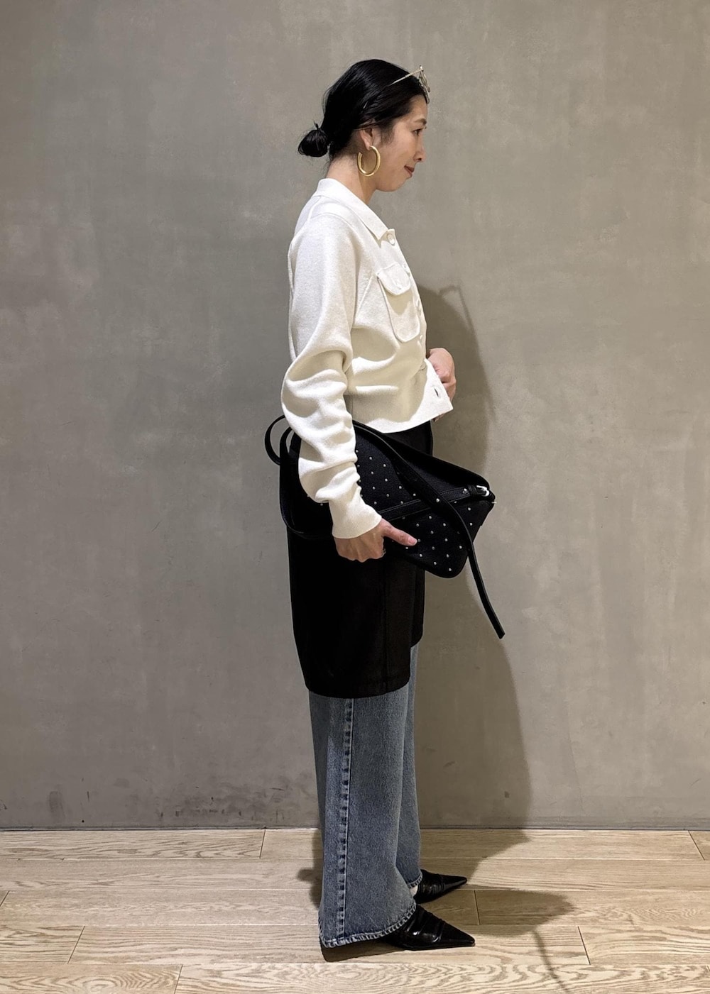 ブラック系のサンダル、ブルー系のデニムパンツ、ブラック系のダウンジャケット/コートを着用したレディースの冬コーディネートの5枚目の写真