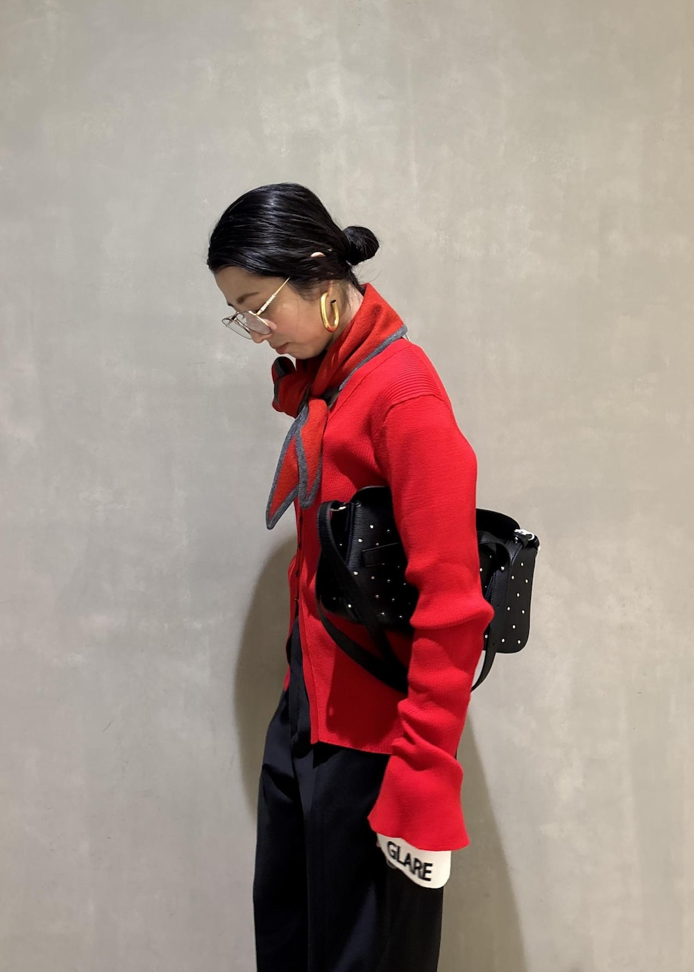 ブラック系のショルダーバッグ、レッド系のカーディガン/ボレロ、ホワイト系のTシャツ/カットソーを着用したレディースの冬コーディネートの10枚目の写真