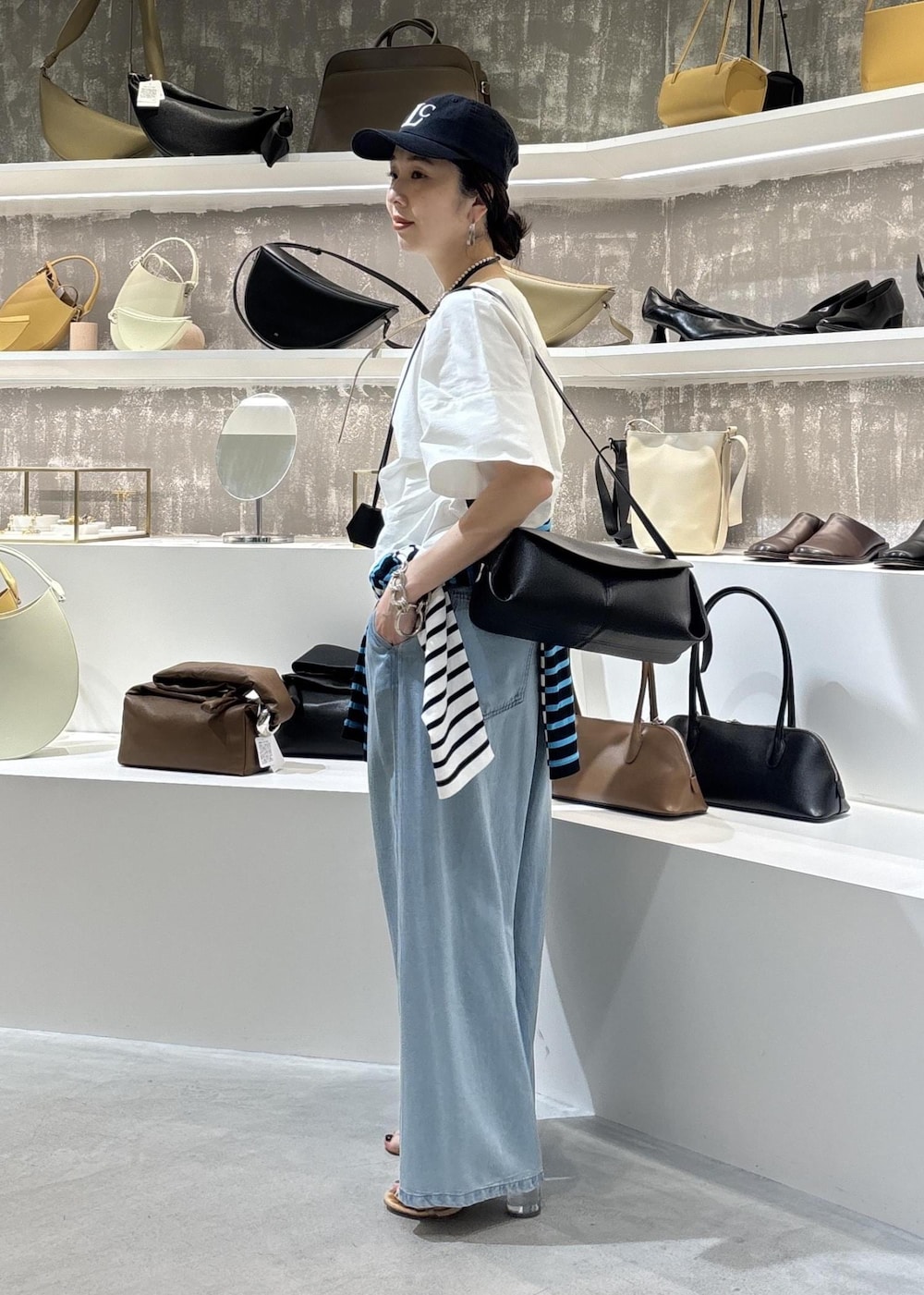 ブルー系のデニムパンツ、ブラック系のショルダーバッグ、ブルー系のTシャツ/カットソーを着用したレディースの春コーディネートの10枚目の写真