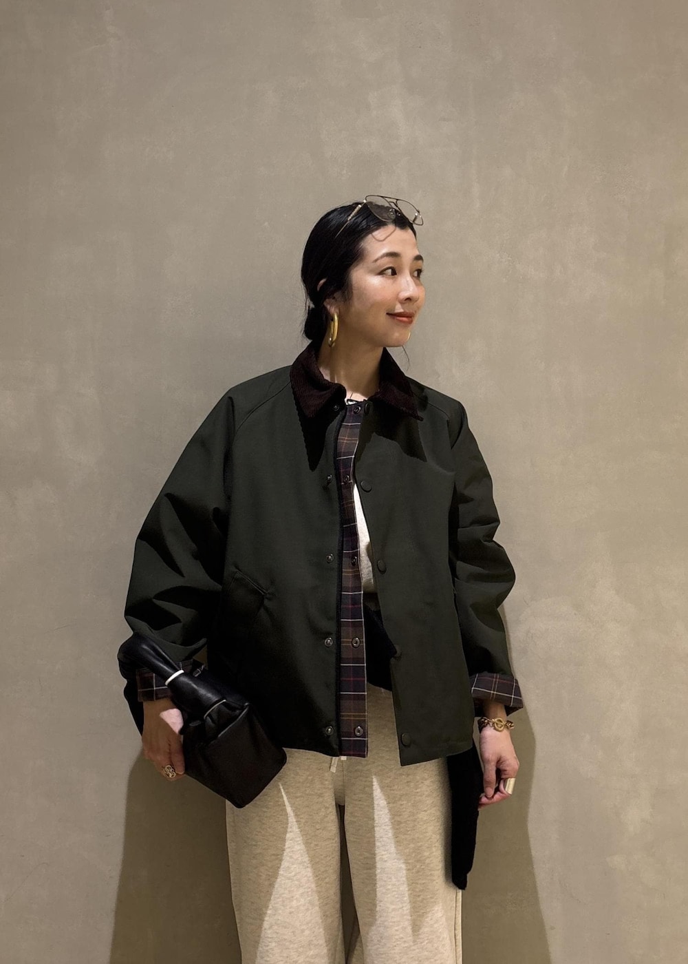 ブラック系のハンドバッグ、グリーン系のその他アウター、ホワイト系のその他パンツを着用したレディースの冬コーディネートの9枚目の写真