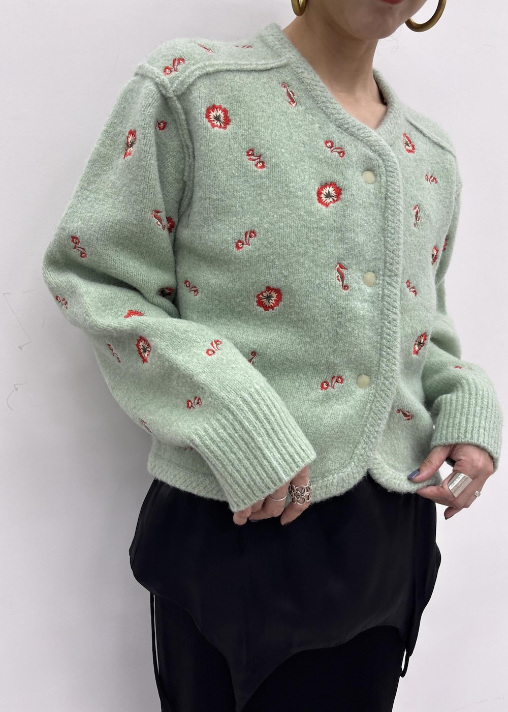 グリーン系のカーディガン/ボレロ、ブルー系のデニムパンツを着用したレディースの秋コーディネートの8枚目の写真