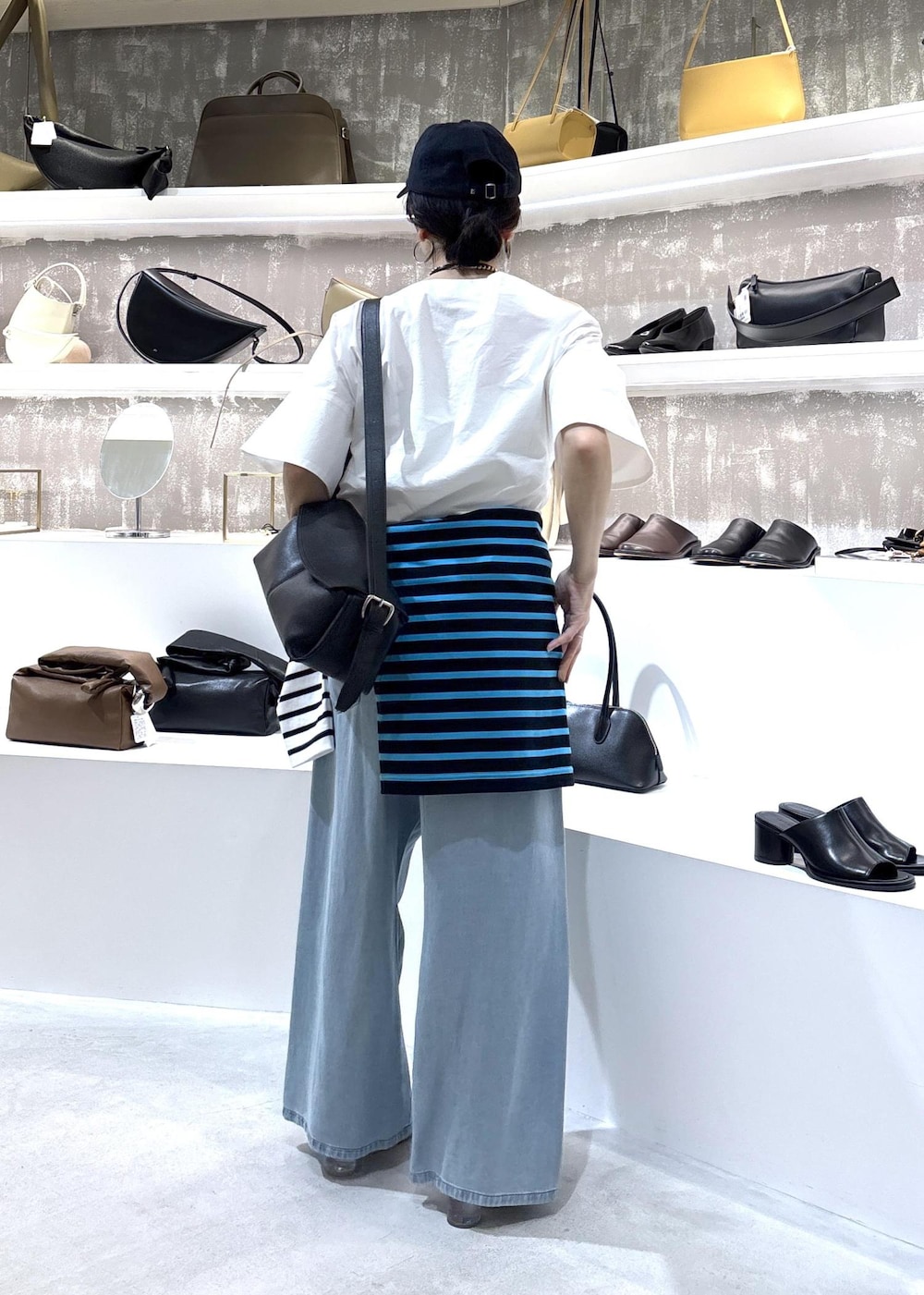 ブルー系のデニムパンツ、ブラック系のショルダーバッグ、ブルー系のTシャツ/カットソーを着用したレディースの春コーディネートの9枚目の写真