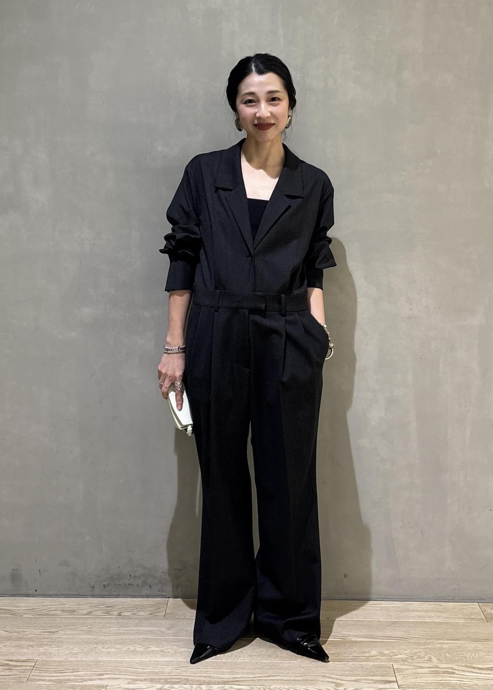 ブラック系のサンダル、グレー系のつなぎ/オールインワン、ホワイト系のキーホルダーを着用したレディースの秋コーディネートの2枚目の写真