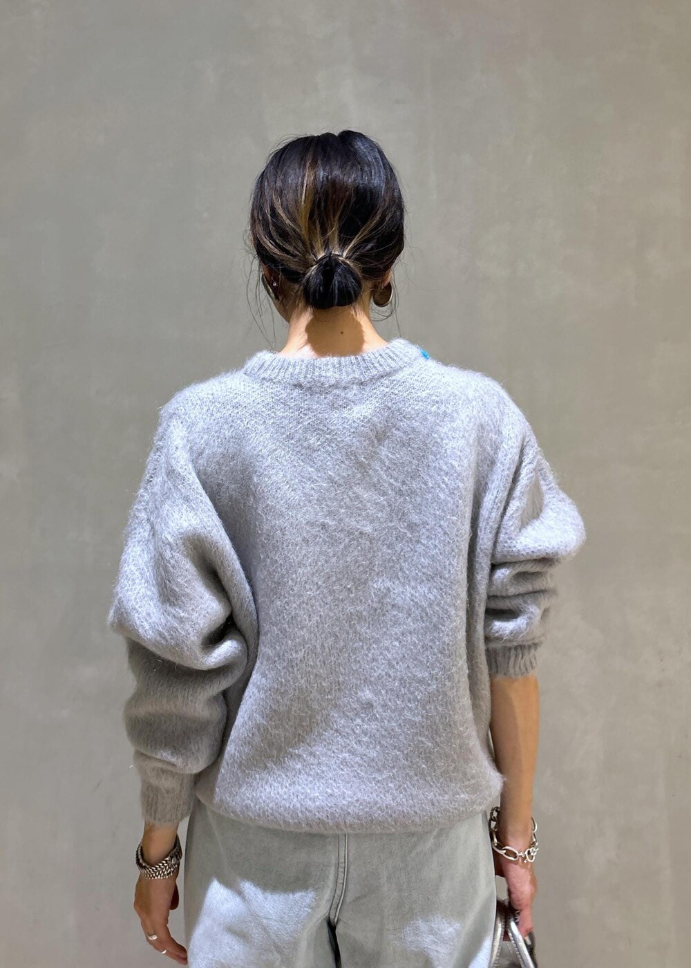 ホワイト系のパンプス、シルバー系のトートバッグ、ブルー系のその他パンツを着用したレディースの秋コーディネートの9枚目の写真