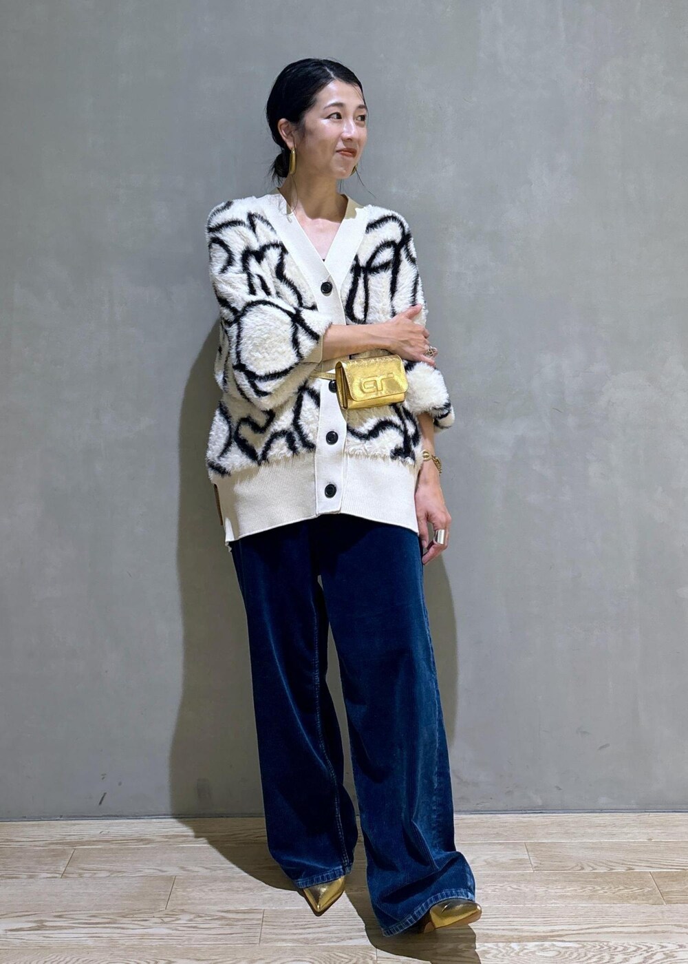 ゴールド系のその他シューズ、ゴールド系のショルダーバッグ、ホワイト系のカーディガン/ボレロを着用したレディースの秋コーディネートの4枚目の写真