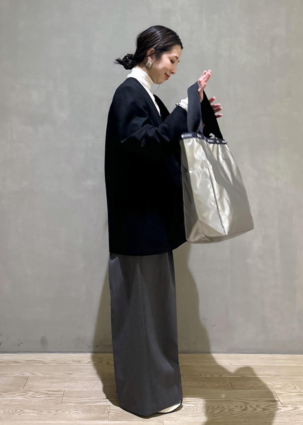 グレー系のスニーカー、ホワイト系のニット/セーター、ブラック系のシャツ/ブラウスを着用したレディースの秋コーディネートの4枚目の写真