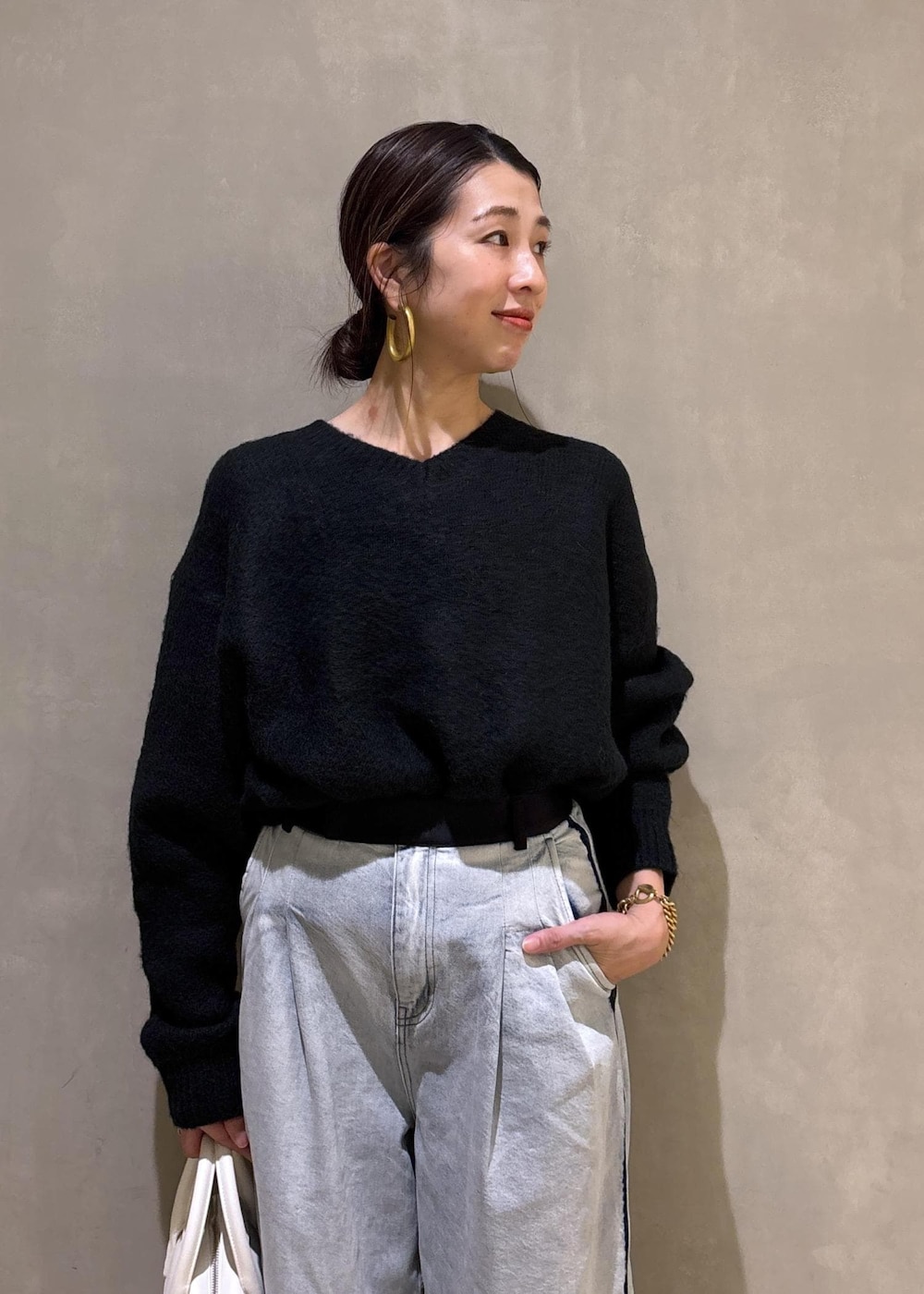 ブラック系のニット/セーター、ホワイト系のボストンバッグ、ブルー系のその他パンツを着用したレディースの冬コーディネートの8枚目の写真