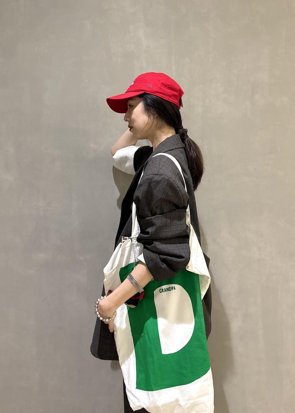 ブラック系のシャツ/ブラウス、グリーン系のトートバッグ、ブラック系のキャップを着用したレディースの秋コーディネートの10枚目の写真