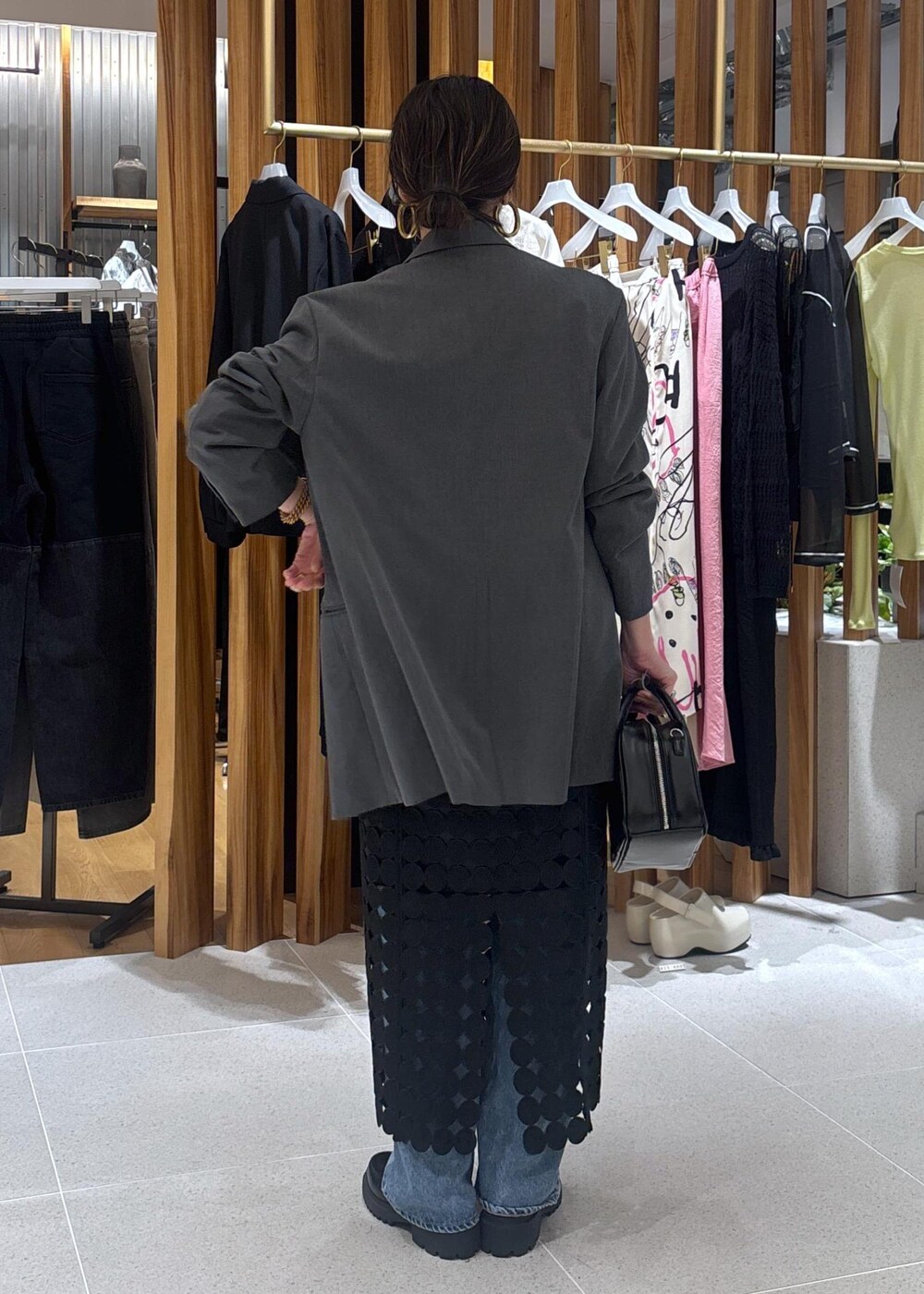 ブルー系のデニムパンツ、グレー系のテーラードジャケット、ブラック系のローファーを着用したレディースの春コーディネートの6枚目の写真