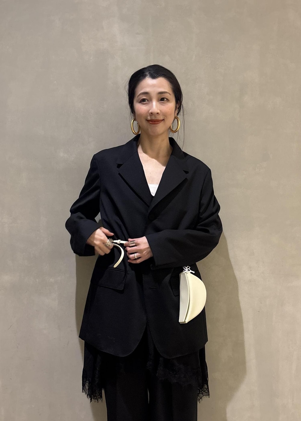 ブラック系のシャツ/ブラウス、ブラック系のテーラードジャケット、ブラック系のスラックスを着用したレディースの冬コーディネートの10枚目の写真