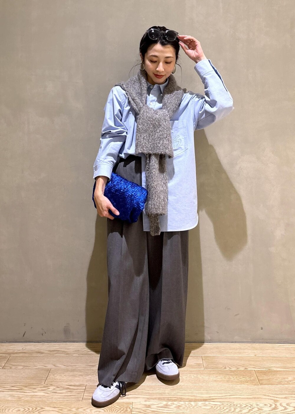 ブルー系のスニーカー、ブルー系のシャツ/ブラウス、グレー系のスラックスを着用したレディースの冬コーディネートの2枚目の写真