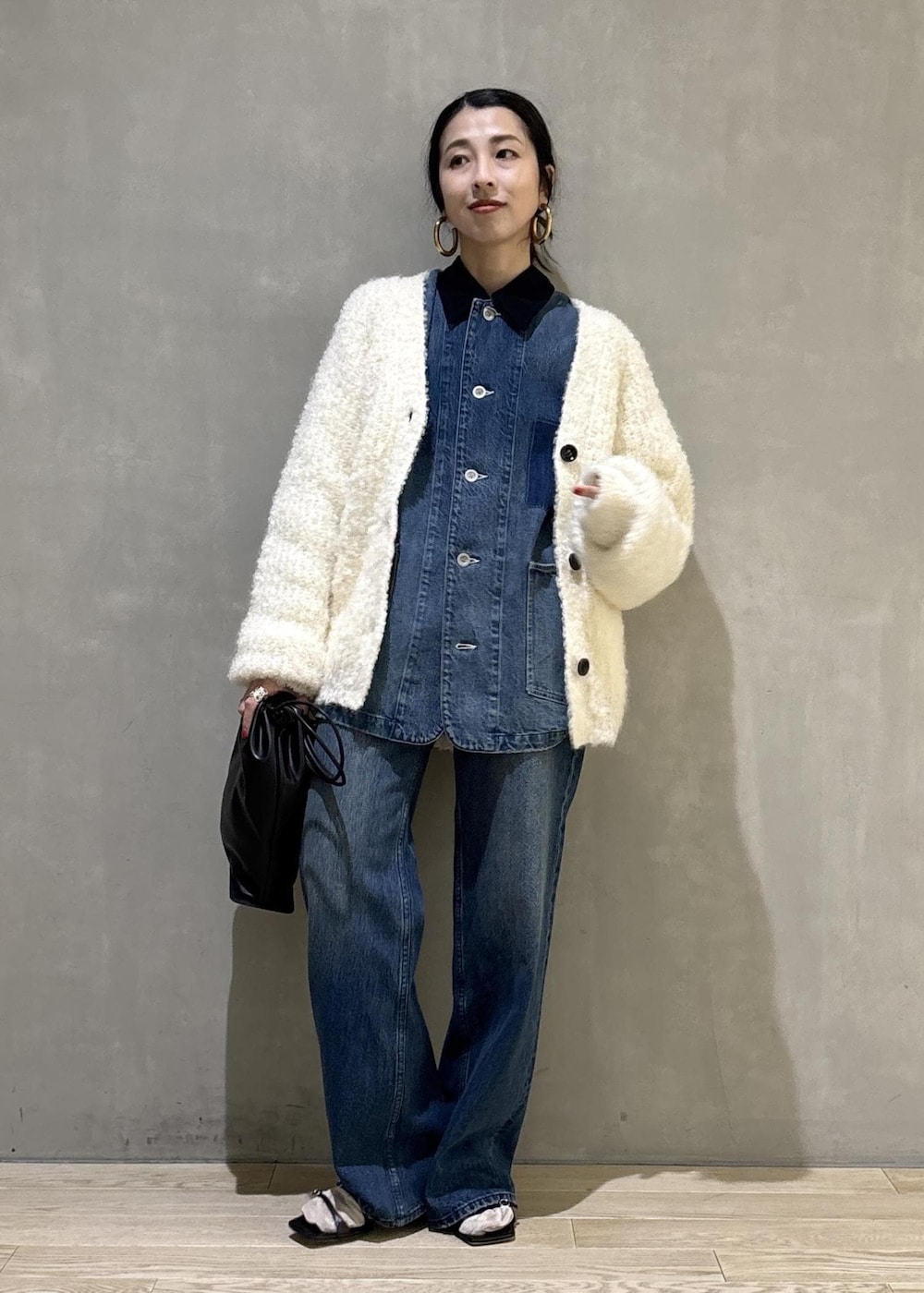 ブラック系のショルダーバッグ、ブルー系のデニムパンツ、ブルー系のカバーオールを着用したレディースの秋コーディネートの7枚目の写真