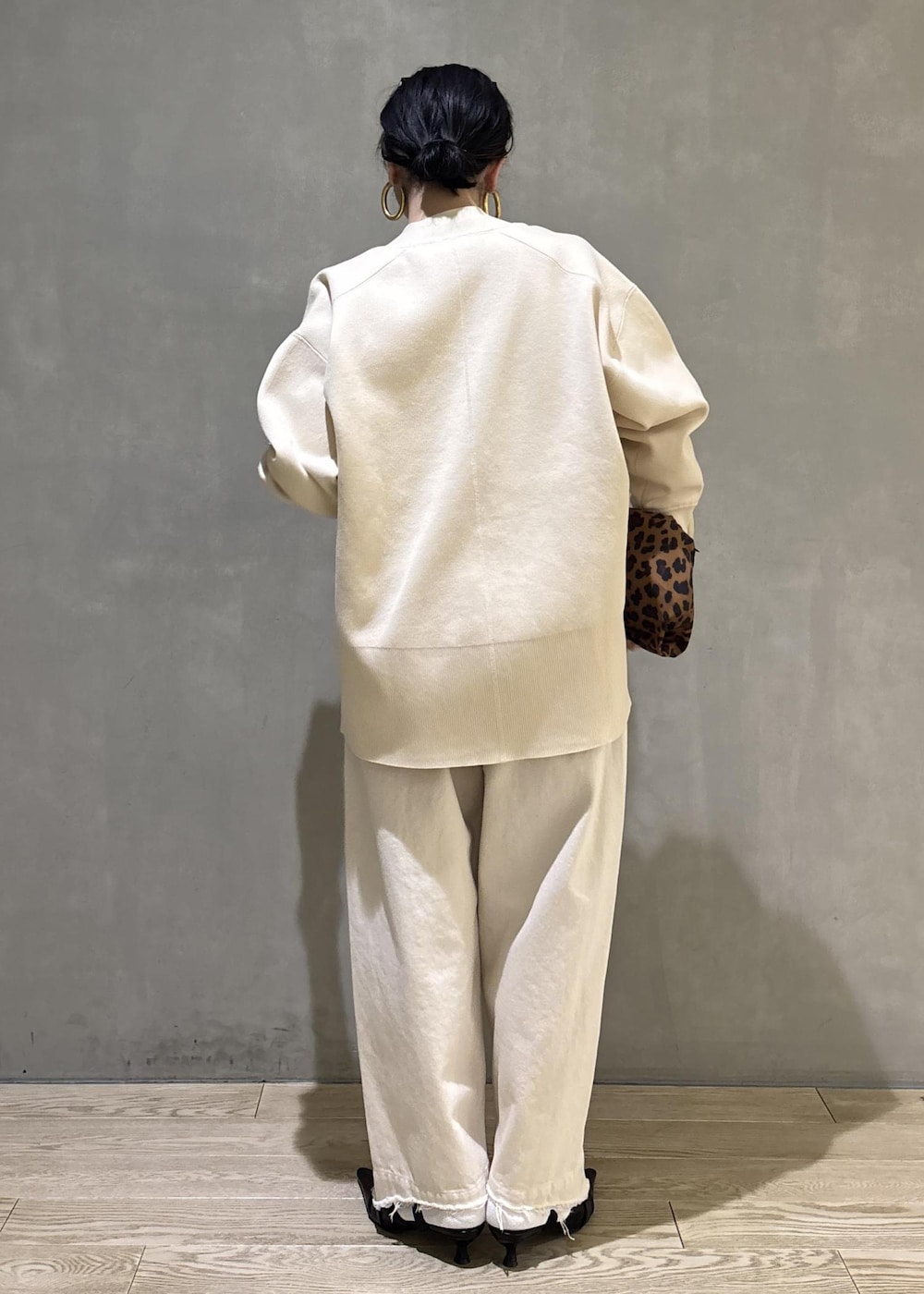 ブラック系のサンダル、ホワイト系のデニムパンツ、ホワイト系のカーディガン/ボレロを着用したレディースの冬コーディネートの6枚目の写真