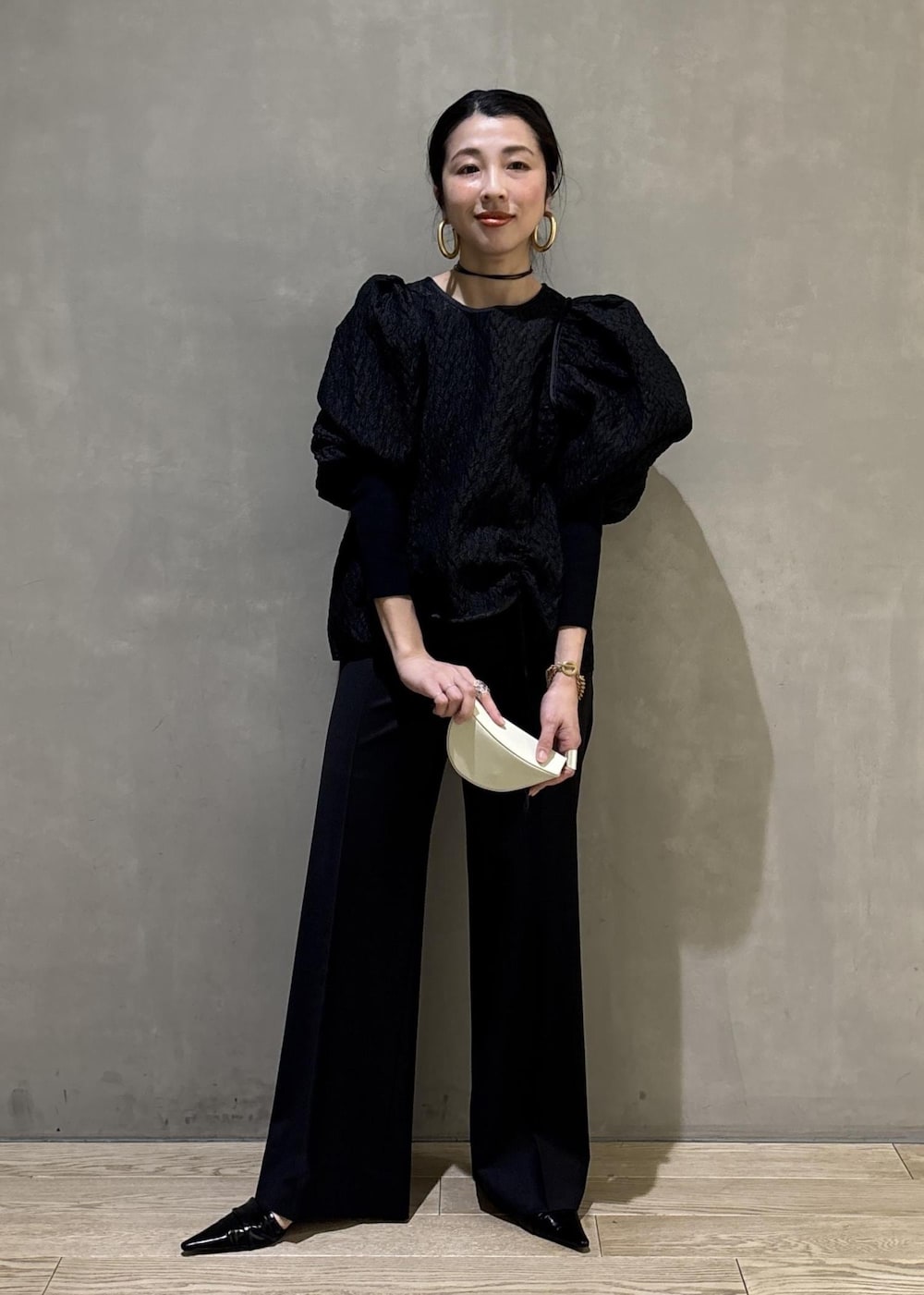 ブラック系のサンダル、ブラック系のスラックス、ブラック系のTシャツ/カットソーを着用したレディースの冬コーディネートの6枚目の写真