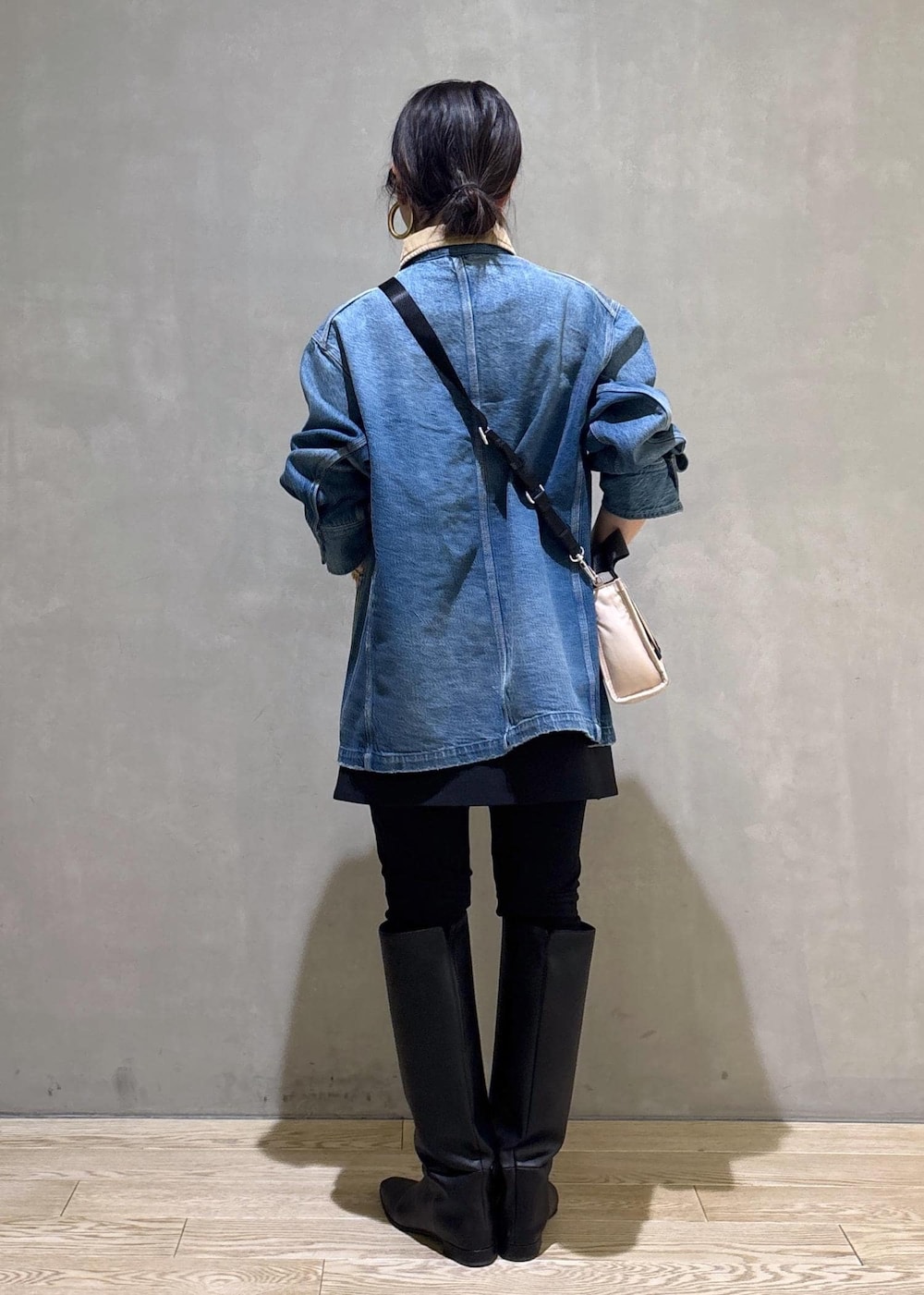 ベージュ系のトートバッグ、ブラック系のブーツ、ブラック系のスカートを着用したレディースの冬コーディネートの4枚目の写真