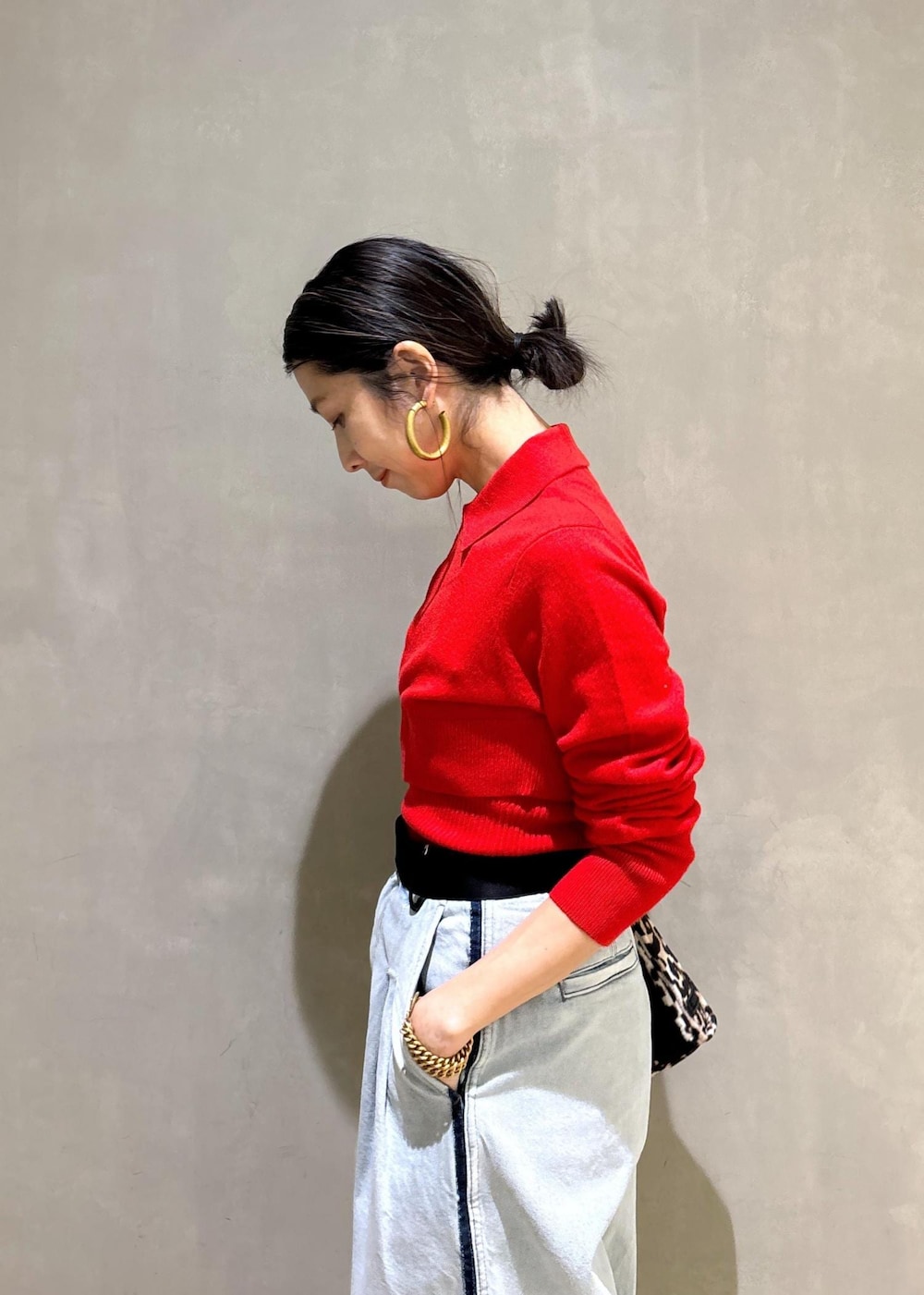 ベージュ系のトートバッグ、ブルー系のその他パンツ、レッド系のカーディガン/ボレロを着用したレディースの秋コーディネートの9枚目の写真