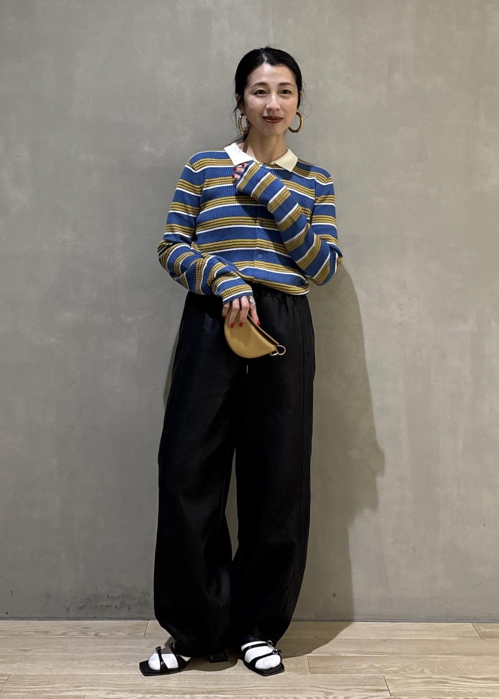 ブルー系のポロシャツ、ブラック系のその他パンツ、イエロー系のキーホルダーを着用したレディースの秋コーディネートの3枚目の写真