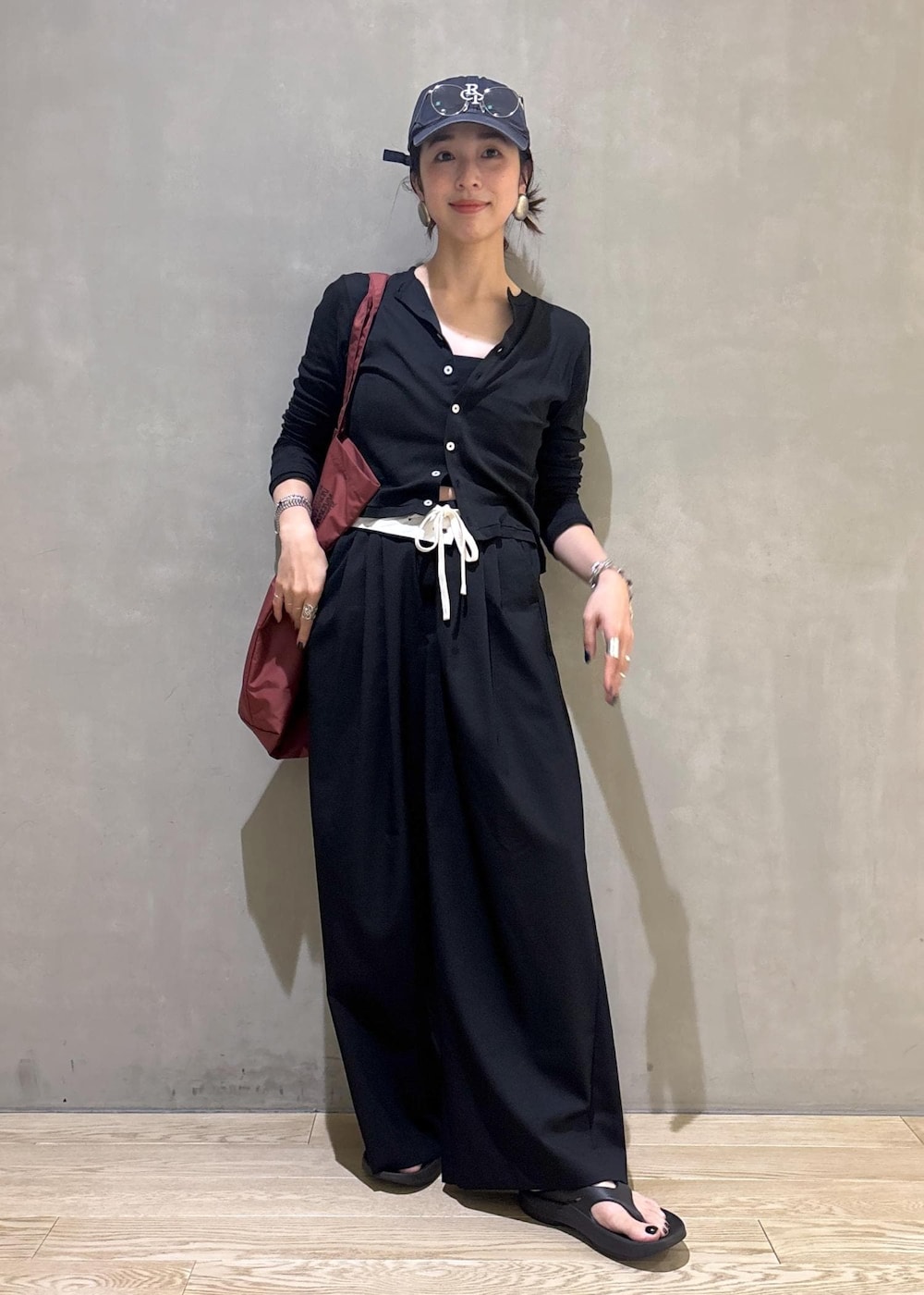 ブラック系のカーディガン/ボレロ、ブラック系のスラックス、シルバー系のサングラスを着用したレディースの夏コーディネートの3枚目の写真