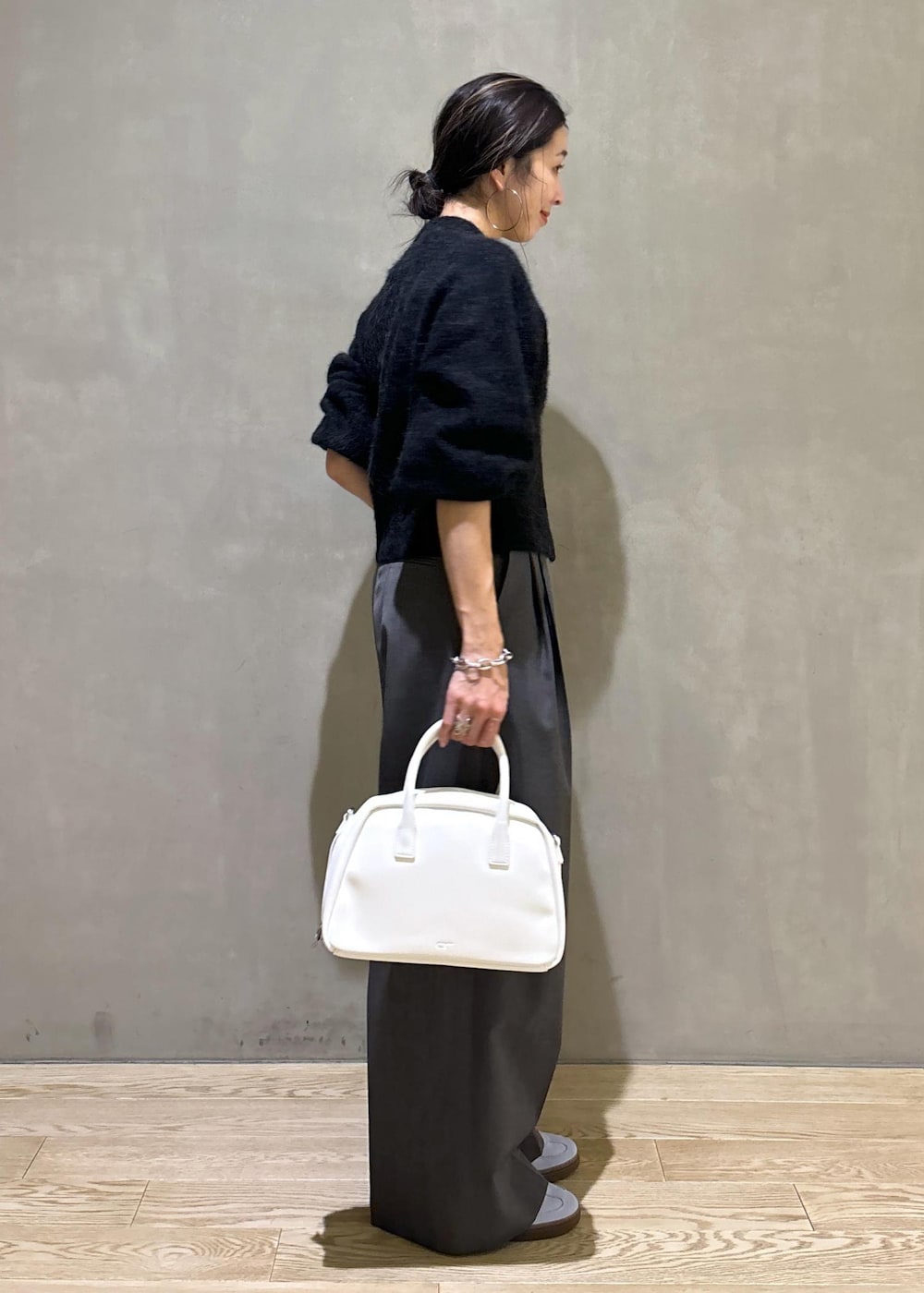 ホワイト系のボストンバッグ、グレー系のカーディガン/ボレロ、ブルー系のスニーカーを着用したレディースの秋コーディネートの4枚目の写真