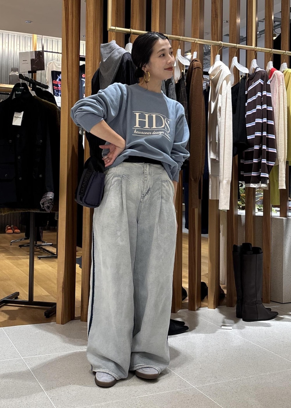 ブルー系のデニムパンツ、ブルー系のショルダーバッグ、ブルー系のスウェットを着用したレディースの秋コーディネートの3枚目の写真