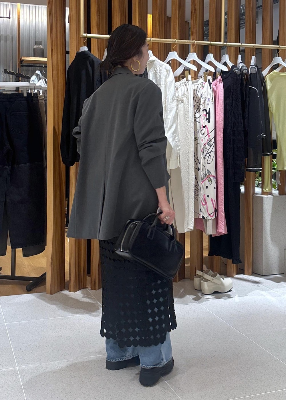 ブルー系のデニムパンツ、グレー系のテーラードジャケット、ブラック系のローファーを着用したレディースの春コーディネートの5枚目の写真