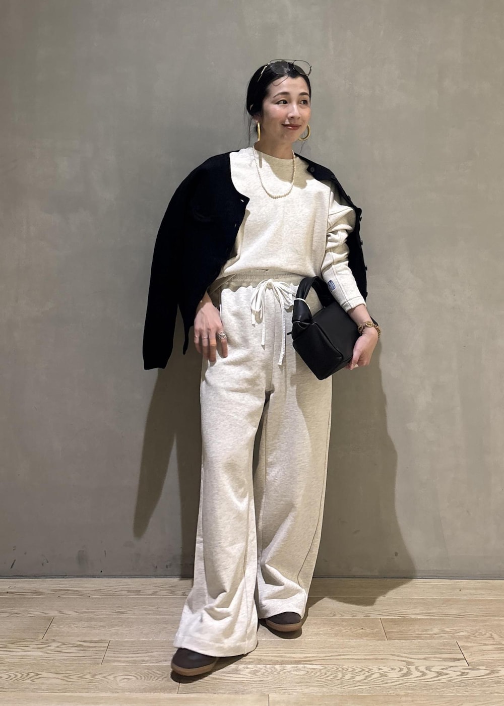 ブラック系のハンドバッグ、ホワイト系のその他パンツ、ホワイト系のスウェットを着用したレディースの冬コーディネートの2枚目の写真