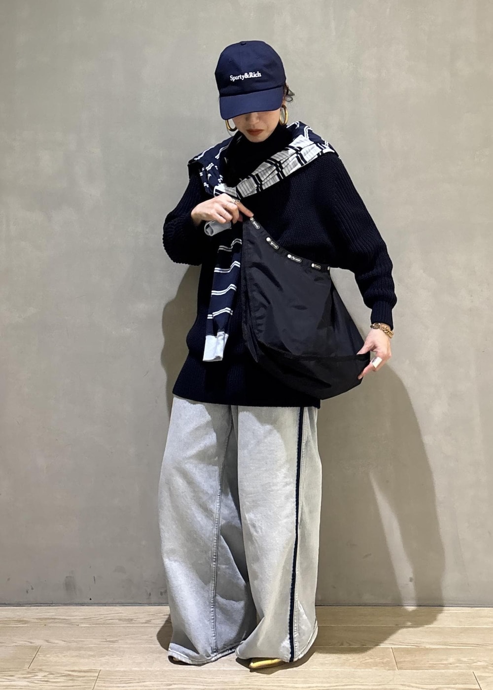 ブルー系のデニムパンツ、ブラック系のショルダーバッグを着用したレディースの秋コーディネートの6枚目の写真