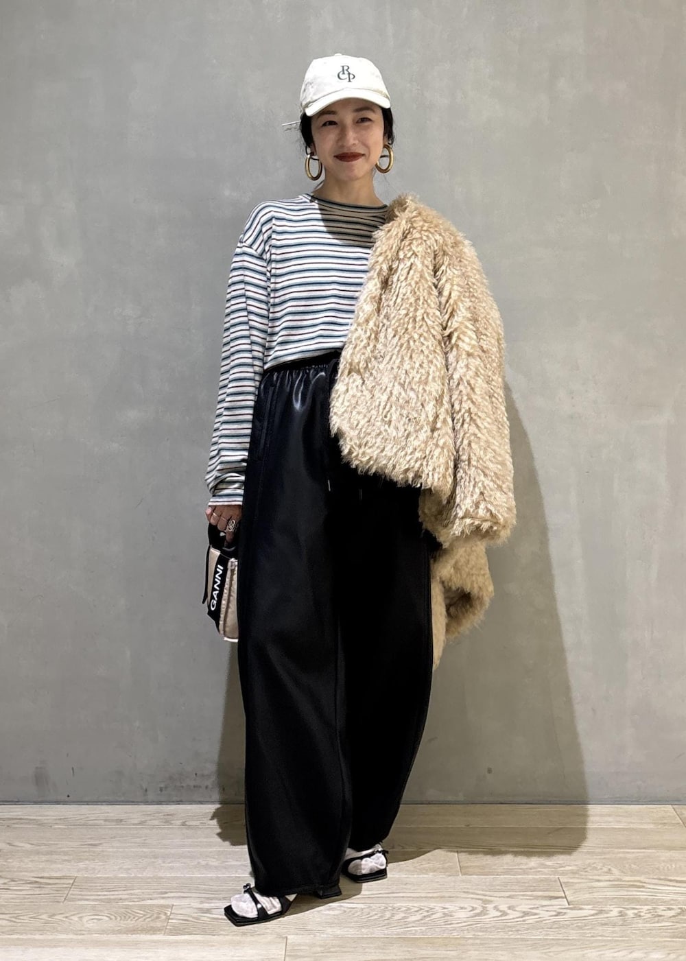 ベージュ系のトートバッグ、ベージュ系のその他アウター、ブラック系のその他パンツを着用したレディースの秋コーディネートの4枚目の写真