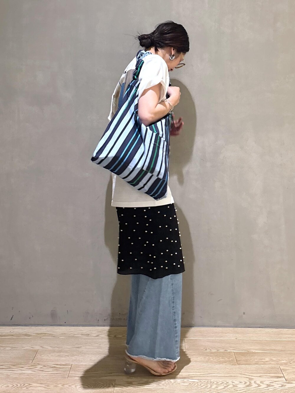 ブルー系のデニムパンツ、ブルー系のショルダーバッグ、ホワイト系のTシャツ/カットソーを着用したレディースの春コーディネートの6枚目の写真