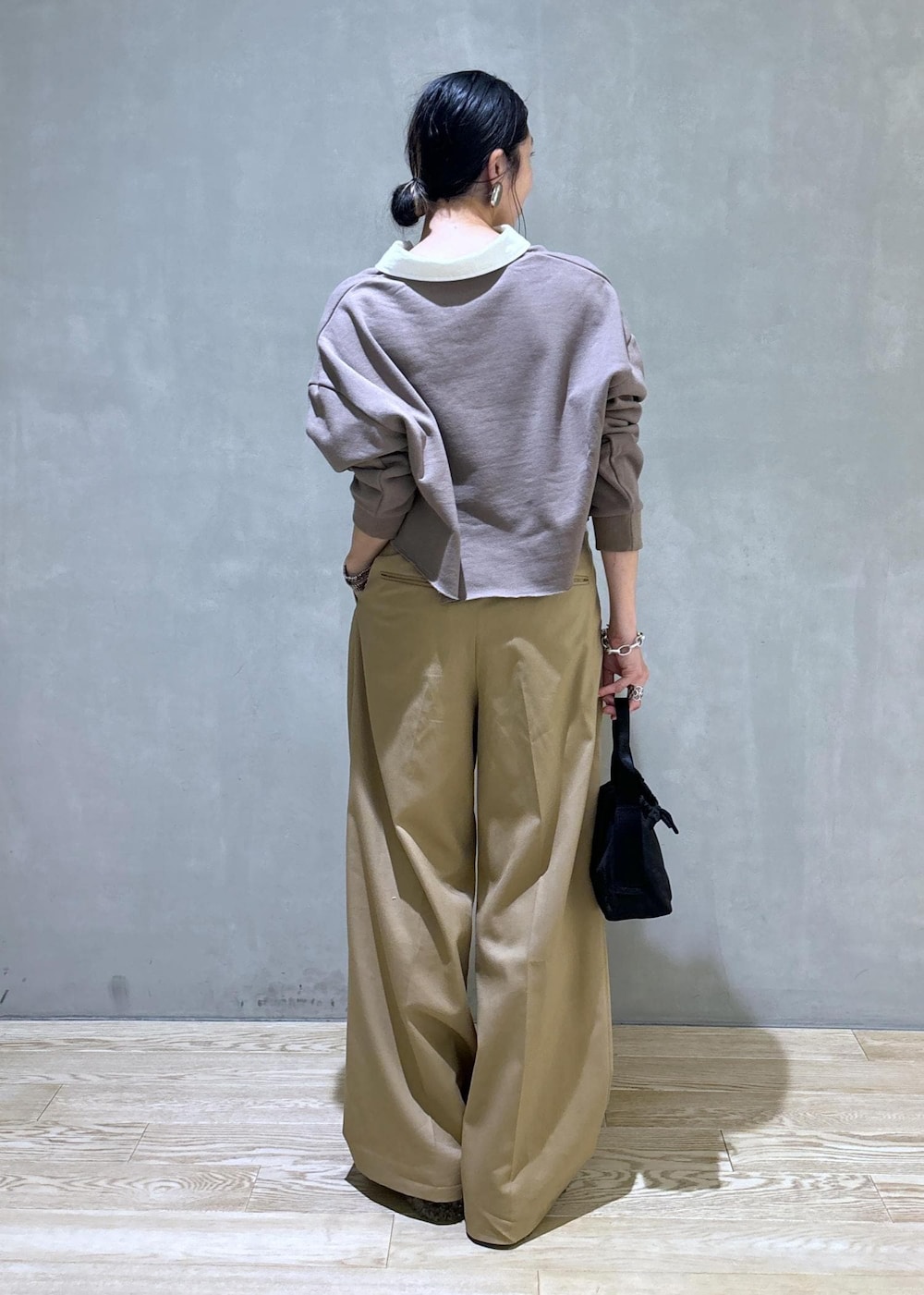 ブラック系のハンドバッグ、ブラウン系のサンダル、ベージュ系のTシャツ/カットソーを着用したレディースの秋コーディネートの3枚目の写真