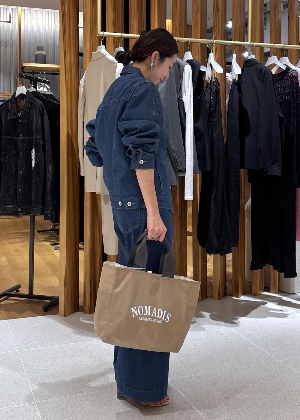 ベージュ系のハンドバッグ、ブルー系のTシャツ/カットソー、ブルー系のブルゾンを着用したレディースの冬コーディネートの6枚目の写真